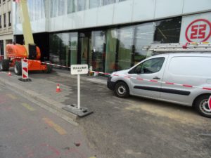 "Vélo à la main" auf dem abgesperrtem Bürgersteig wo Fahrzeuge draufstehen
