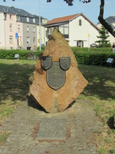 Ein grosser Stein, mit dem Spruch "Fir eis Fräiheet - Gescht Haut Mar", und den Wappen der Gemeinde Küntzig und Luxemburgs